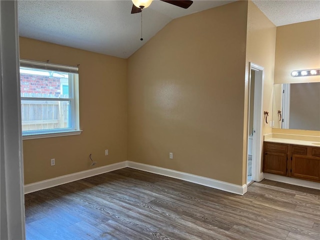 2506 S Sugar Ridge Dr, La Place, LA 70068 - empty room featuring a ceiling fan, dark wood finished floors, lofted ceiling, baseboards, and a textured ceiling