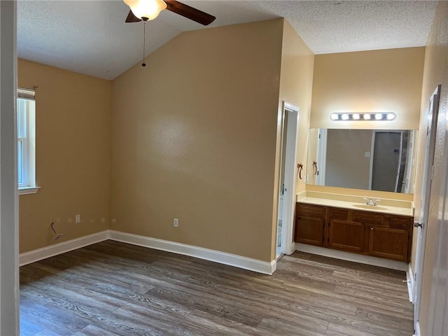 2506 S Sugar Ridge Dr, La Place, LA 70068 - unfurnished bedroom with dark wood-style floors, lofted ceiling, a sink, ensuite bathroom, and a textured ceiling