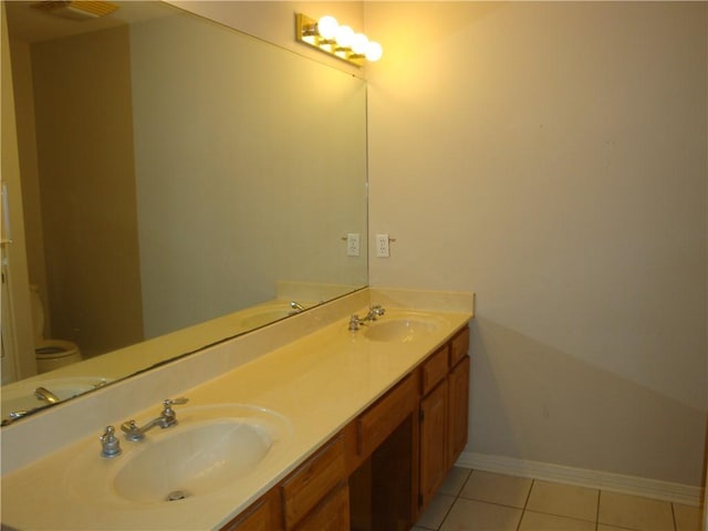 20282 Florence St, Covington, LA 70435 - bathroom featuring double vanity, tile patterned floors, baseboards, and toilet