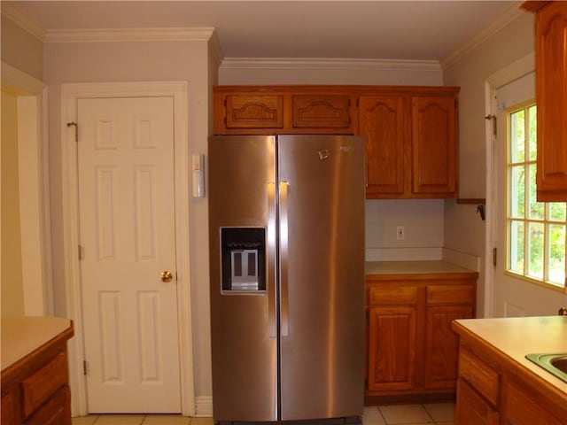 20282 Florence St, Covington, LA 70435 - kitchen with stainless steel refrigerator with ice dispenser, light countertops, brown cabinetry, ornamental molding, and light tile patterned floors