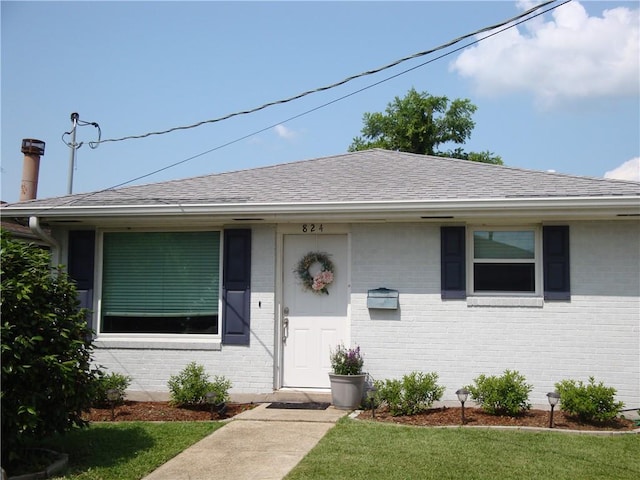 824 Oak Ave, Harahan, LA 70123 - view of front of house with brick siding, a front yard, and roof with shingles