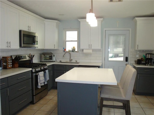 824 Oak Ave, Harahan, LA 70123 - kitchen featuring appliances with stainless steel finishes, a sink, decorative backsplash, and white cabinetry