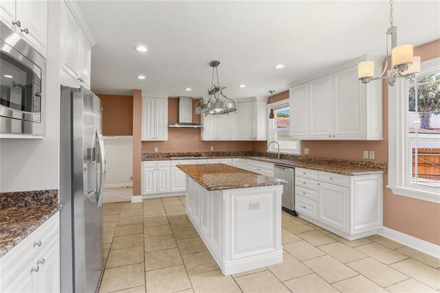 6141 Canal Blvd, New Orleans, LA 70124 - kitchen featuring appliances with stainless steel finishes, wall chimney exhaust hood, a sink, a chandelier, and white cabinets