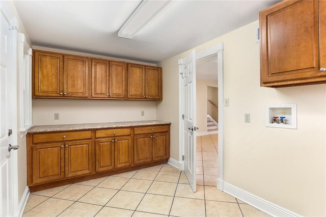 6141 Canal Blvd, New Orleans, LA 70124 - laundry room with cabinet space, washer hookup, light tile patterned floors, and baseboards