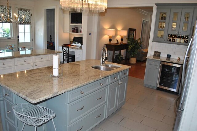 6925 Canal Blvd, New Orleans, LA 70124 - kitchen with a kitchen island with sink, white cabinets, decorative light fixtures, light stone countertops, and a chandelier