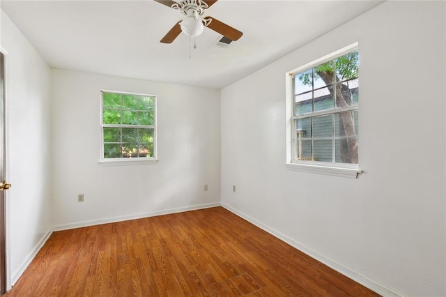 811 Tricou St, New Orleans, LA 70117 - empty room with plenty of natural light, wood finished floors, and baseboards