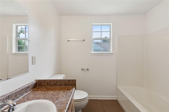 811 Tricou St, New Orleans, LA 70117 - full bathroom with toilet, vanity, tile patterned flooring, and healthy amount of natural light