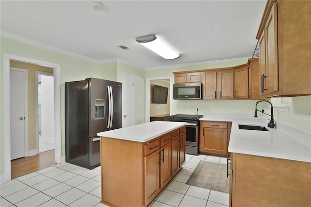 1517 Frankel Ave, Metairie, LA 70003 - kitchen with appliances with stainless steel finishes, a sink, crown molding, light tile patterned floors, and a center island