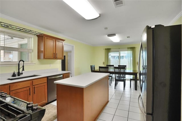 1517 Frankel Ave, Metairie, LA 70003 - kitchen featuring stainless steel appliances, a sink, light countertops, crown molding, and a center island