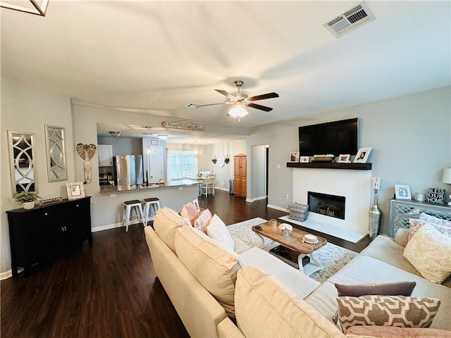306 Allie Ln, Luling, LA 70070 - living room with dark wood-style floors, baseboards, a ceiling fan, and a fireplace
