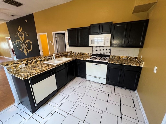 320 De Armas St, New Orleans, LA 70114 - kitchen featuring white appliances, dark cabinetry, a sink, and backsplash
