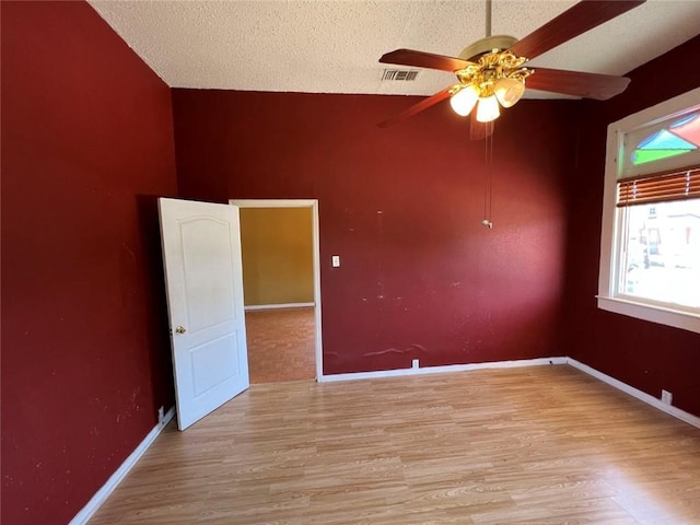 320 De Armas St, New Orleans, LA 70114 - spare room featuring ceiling fan, light wood-type flooring, lofted ceiling, a textured ceiling, and baseboards