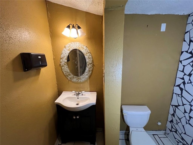 320 De Armas St, New Orleans, LA 70114 - bathroom featuring vanity, toilet, tile patterned flooring, and a textured ceiling