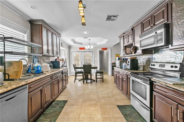 11276 Fernley Dr, New Orleans, LA 70128 - kitchen with stainless steel appliances, a chandelier, tasteful backsplash, light tile patterned flooring, and crown molding