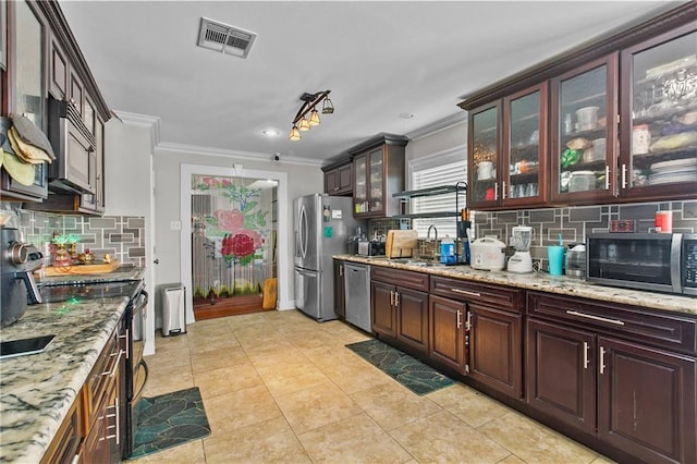 11276 Fernley Dr, New Orleans, LA 70128 - kitchen featuring appliances with stainless steel finishes, crown molding, decorative backsplash, light stone countertops, and a sink