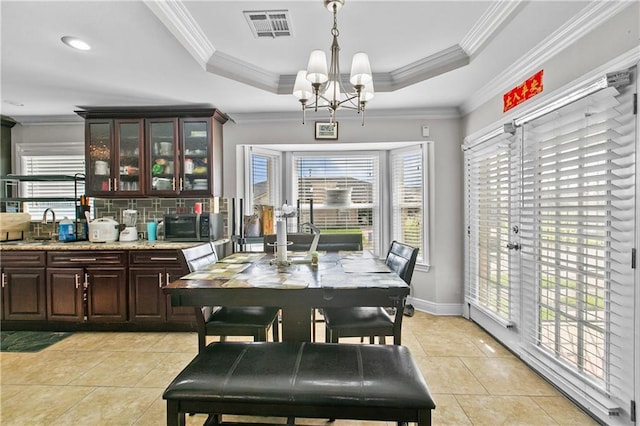 11276 Fernley Dr, New Orleans, LA 70128 - dining room featuring healthy amount of natural light, a chandelier, light tile patterned flooring, and crown molding