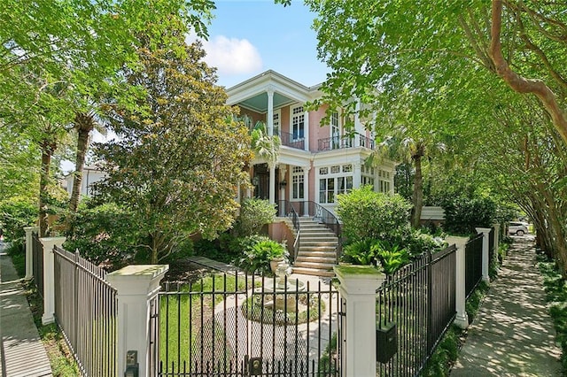 1633 Dufossat St, New Orleans, LA 70115 - greek revival house with a balcony, a fenced front yard, stairs, and a gate