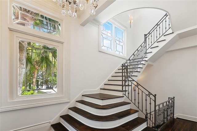 1633 Dufossat St, New Orleans, LA 70115 - stairs featuring healthy amount of natural light, wood finished floors, a chandelier, a high ceiling, and baseboards
