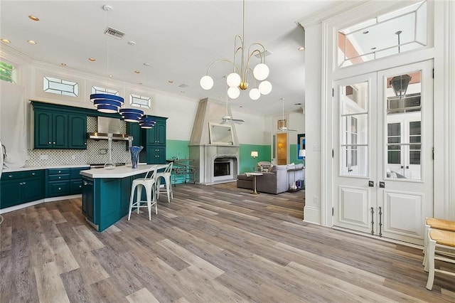 1633 Dufossat St, New Orleans, LA 70115 - kitchen featuring light countertops, wood finished floors, a kitchen breakfast bar, a center island with sink, and recessed lighting