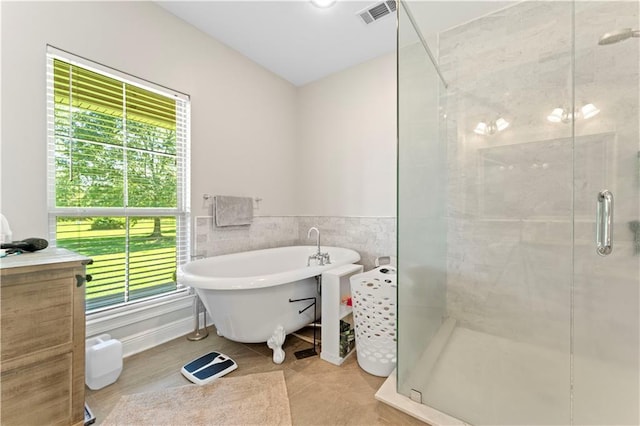 25766 La Highway 1032, Denham Springs, LA 70726 - bathroom with a stall shower, a soaking tub, vanity, tile walls, and tile patterned flooring