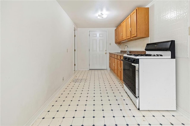 401 Oak Ave, Harahan, LA 70123 - kitchen featuring white range with gas cooktop, baseboards, light flooring, and a sink