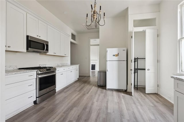 2305 Soniat St, New Orleans, LA 70115 - kitchen featuring stainless steel appliances, light wood-style floors, white cabinetry, and a chandelier