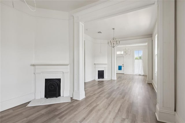2305 Soniat St, New Orleans, LA 70115 - unfurnished living room featuring a fireplace with raised hearth, wood finished floors, a chandelier, and baseboards