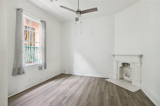 2305 Soniat St, New Orleans, LA 70115 - unfurnished living room with wood finished floors, ceiling fan, a fireplace, and baseboards