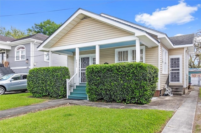 2622 Wisteria St, New Orleans, LA 70122 - view of front of home with covered porch, a front lawn, roof with shingles, and entry steps