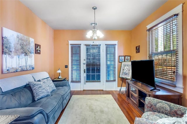 2622 Wisteria St, New Orleans, LA 70122 - living room featuring wood finished floors and a chandelier