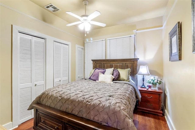 2622 Wisteria St, New Orleans, LA 70122 - bedroom featuring two closets, wood finished floors, baseboards, and ceiling fan