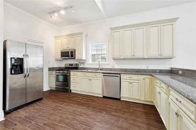 3316 Calhoun St, New Orleans, LA 70125 - kitchen with stainless steel appliances, cream cabinets, rail lighting, a sink, and ornamental molding