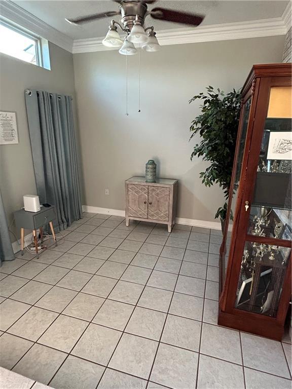 1705 Armagh Dr, Marrero, LA 70072 - spare room featuring ceiling fan, light tile patterned flooring, crown molding, and baseboards