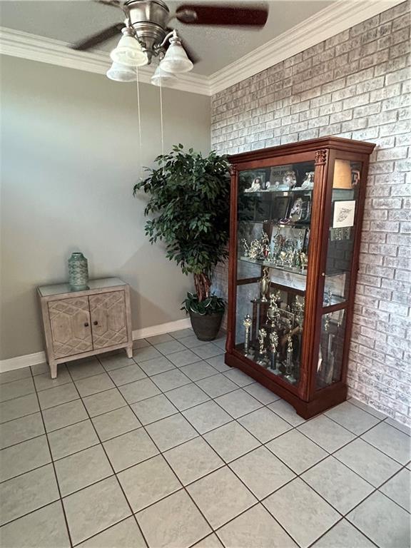 1705 Armagh Dr, Marrero, LA 70072 - interior space featuring a ceiling fan, ornamental molding, brick wall, and baseboards