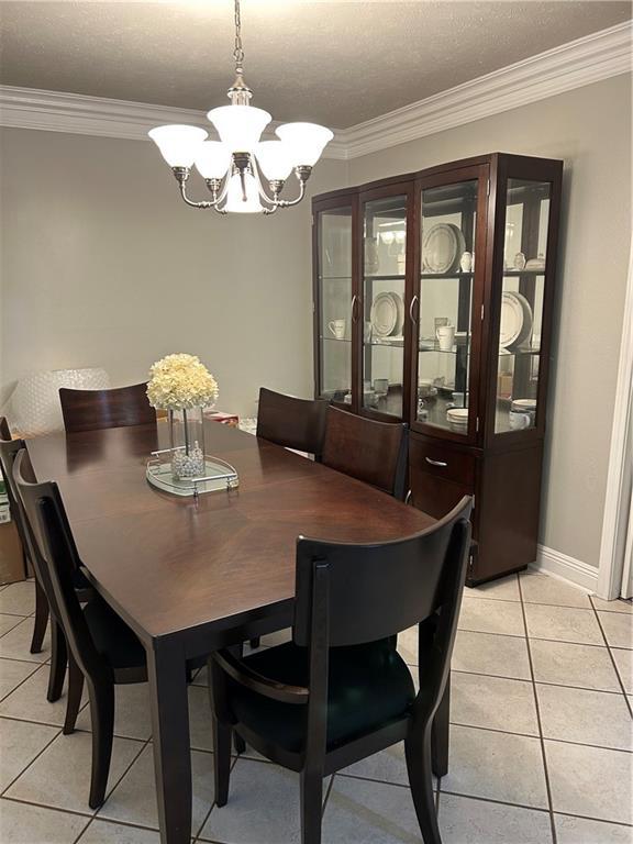 1705 Armagh Dr, Marrero, LA 70072 - dining room featuring a chandelier, ornamental molding, light tile patterned floors, and baseboards