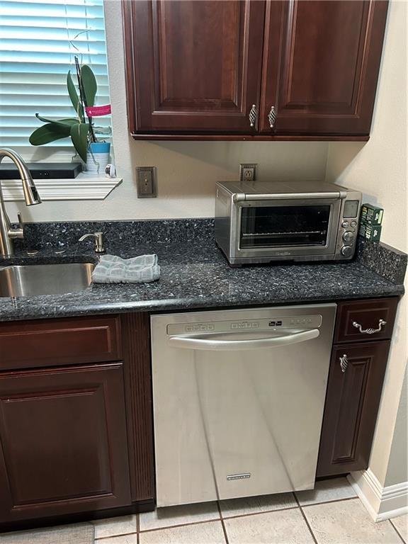 1705 Armagh Dr, Marrero, LA 70072 - kitchen featuring dishwasher, dark brown cabinets, a sink, light tile patterned flooring, and dark stone countertops