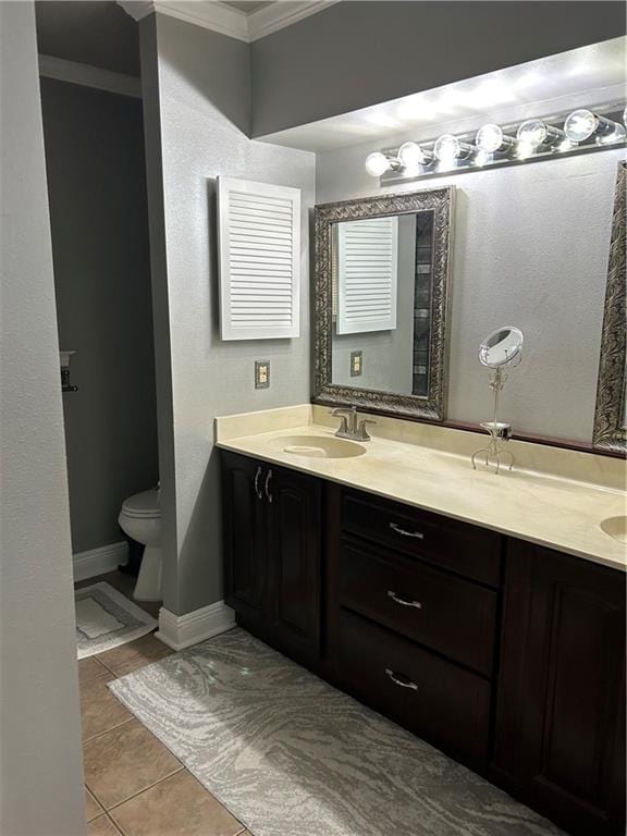 1705 Armagh Dr, Marrero, LA 70072 - bathroom featuring crown molding, double vanity, tile patterned flooring, toilet, and baseboards
