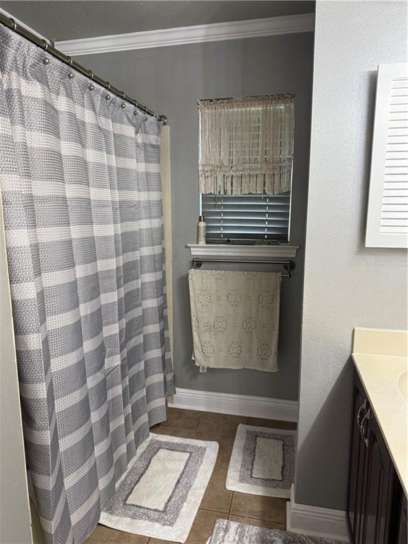 1705 Armagh Dr, Marrero, LA 70072 - bathroom featuring tile patterned floors, ornamental molding, vanity, baseboards, and a shower with shower curtain