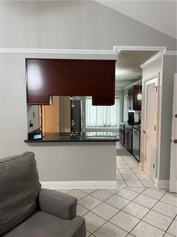 1705 Armagh Dr, Marrero, LA 70072 - kitchen with dark countertops, light tile patterned flooring, freestanding refrigerator, stainless steel dishwasher, and vaulted ceiling