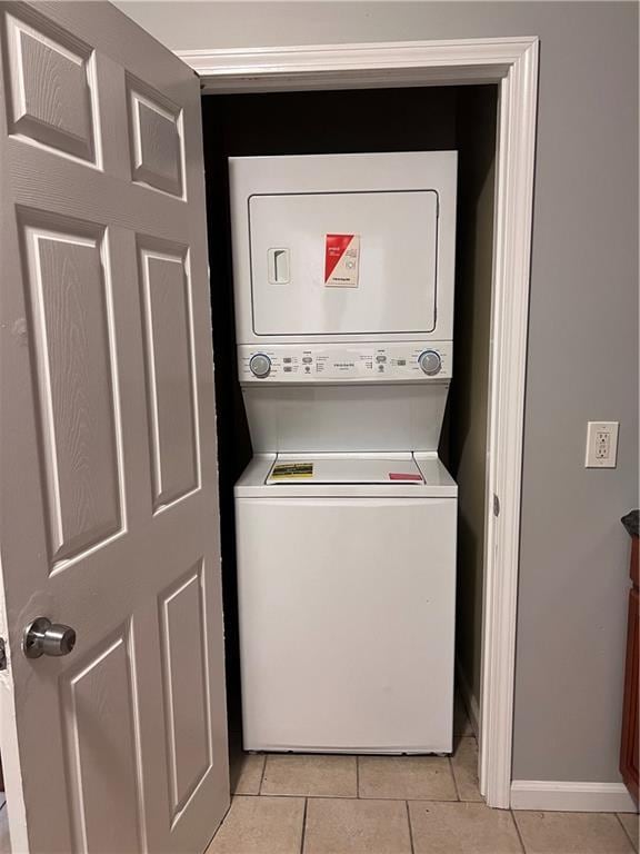 1133-35 Belleville St, New Orleans, LA 70114 - laundry area featuring stacked washing machine and dryer, light tile patterned floors, and baseboards