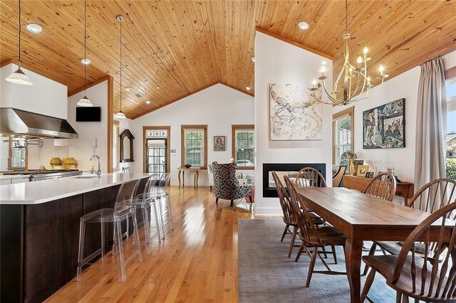 602 Jefferson Ave, New Orleans, LA 70115 - dining room featuring wooden ceiling, a chandelier, light wood-style floors, a fireplace, and high vaulted ceiling