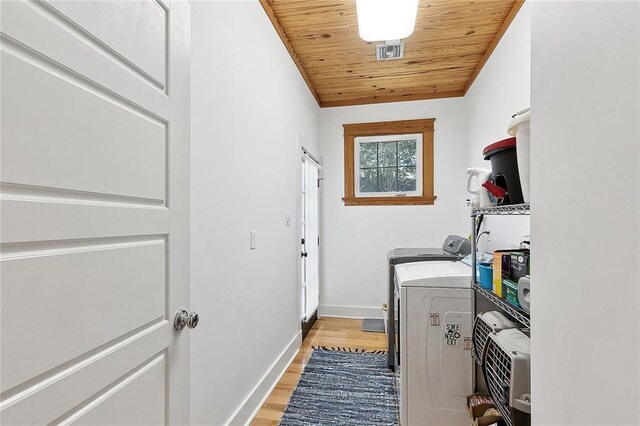 602 Jefferson Ave, New Orleans, LA 70115 - laundry room with light wood-type flooring, wood ceiling, washer and clothes dryer, and baseboards