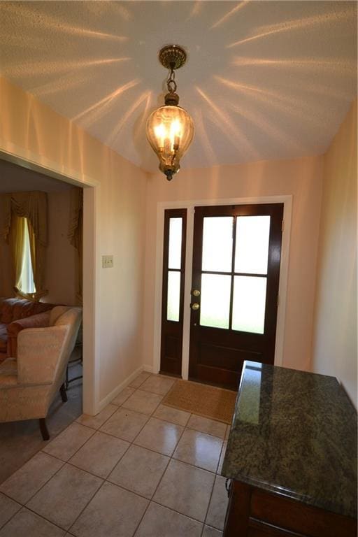 102 Apple Ct, Luling, LA 70070 - foyer entrance featuring light tile patterned floors, a chandelier, and baseboards