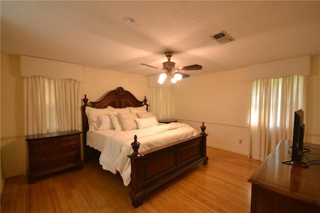 102 Apple Ct, Luling, LA 70070 - bedroom featuring light wood-style floors, a textured ceiling, a ceiling fan, and baseboards