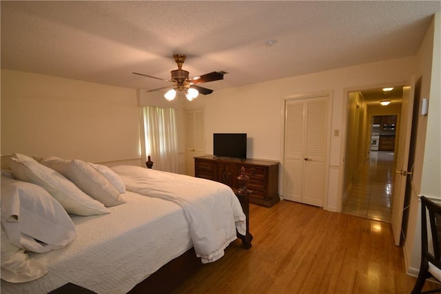 102 Apple Ct, Luling, LA 70070 - bedroom with a textured ceiling, light wood finished floors, ceiling fan, and multiple closets