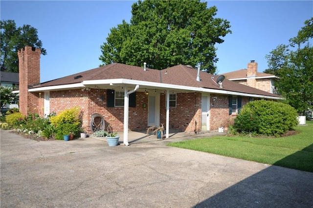 102 Apple Ct, Luling, LA 70070 - back of house with a chimney, brick siding, and a lawn