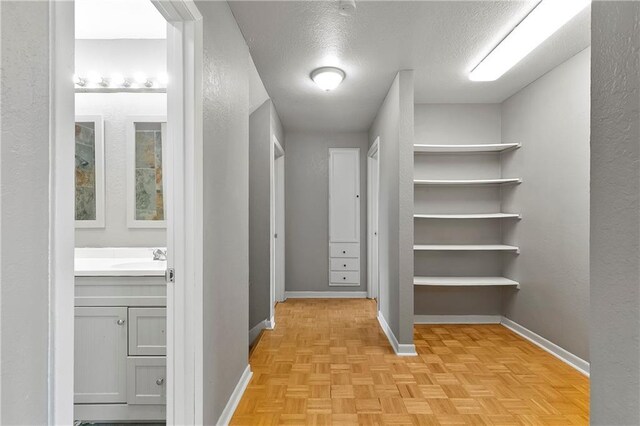 312 Tamarack St, Gretna, LA 70056 - corridor with baseboards, a textured ceiling, a textured wall, and a sink