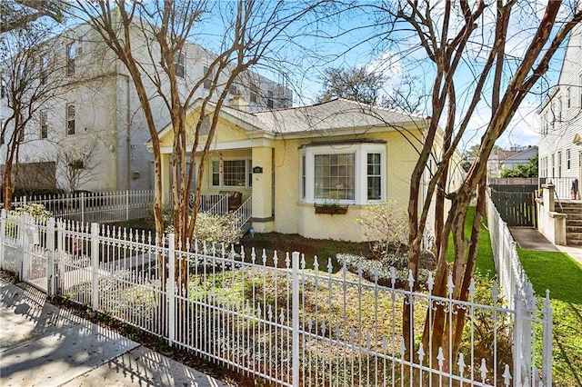 6118 Canal Blvd, New Orleans, LA 70124 - view of front of house with a fenced front yard, a shingled roof, and stucco siding