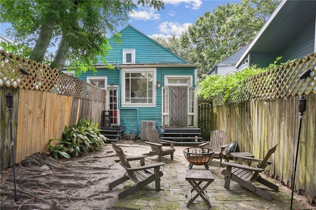 921-23 Hagan Ave, New Orleans, LA 70119 - rear view of house featuring a fenced backyard, an outdoor fire pit, central air condition unit, and a patio area