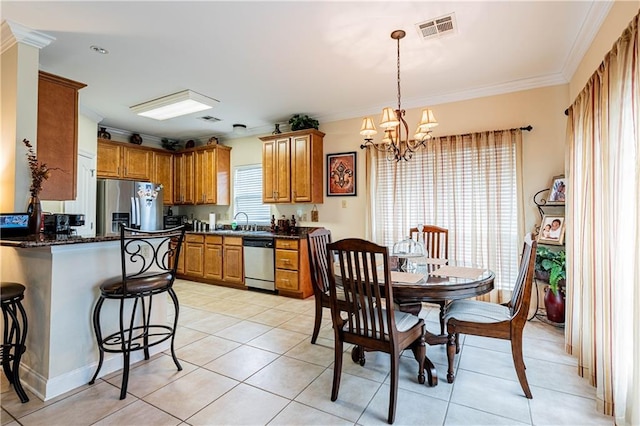 1326 Prentiss Ave, New Orleans, LA 70122 - kitchen featuring stainless steel appliances, ornamental molding, a chandelier, brown cabinets, and a kitchen bar